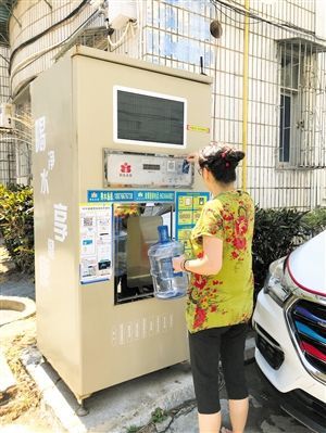 5月24日，瓊山區(qū)上丹花苑小區(qū)居民陳女士在使用共享凈水機(jī)取水。 本報(bào)記者 陳歆卓 攝